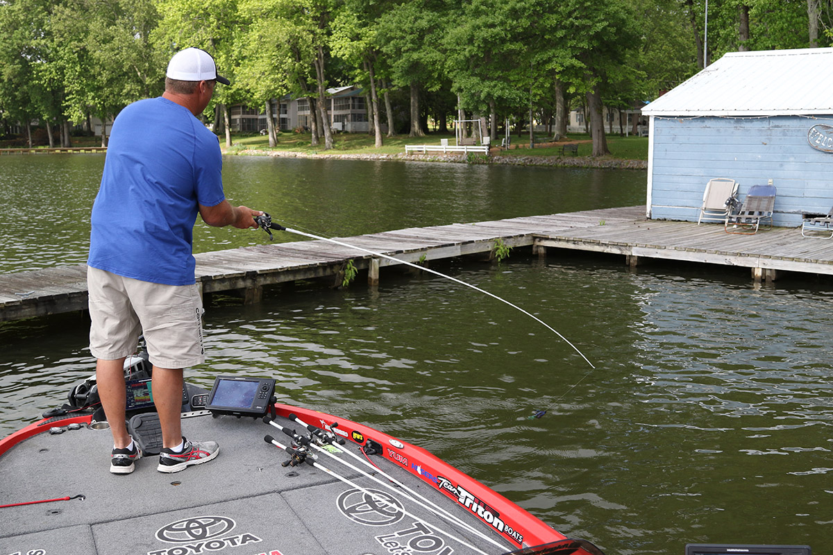 Man fishing for bass at a dock in summer