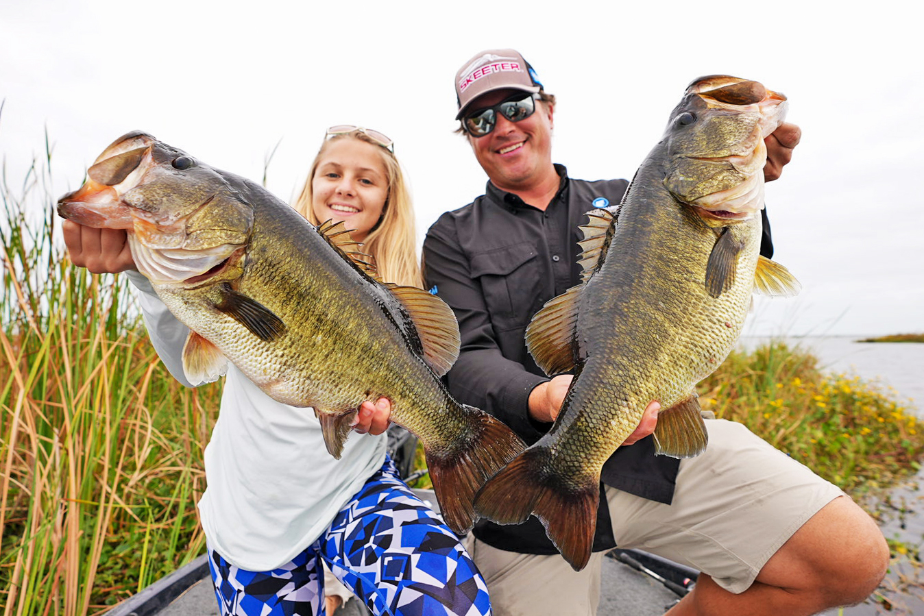 Man and female holding up large Bass caught fishing in Florida in early spawn period