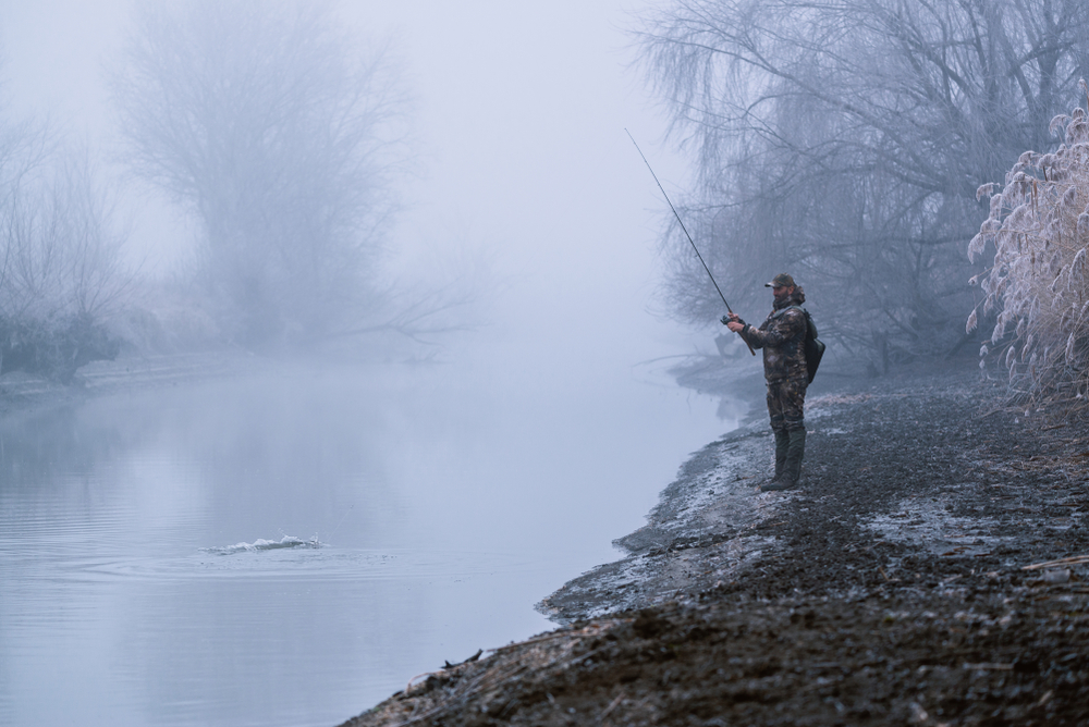 Biggest bass fishing myths - a man fishing for bass in winter.