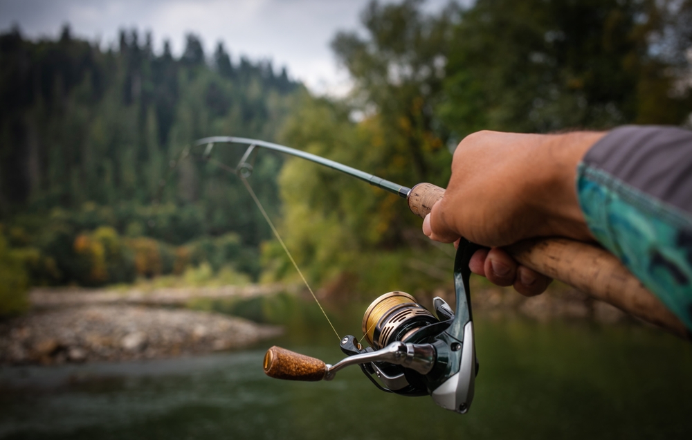 A man fishing in the shade to catch bass in summer.