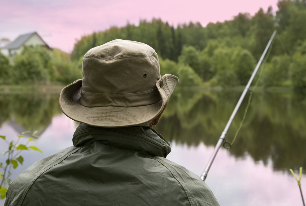 What to bring on a fishing trip - a man wearing a fishing hat.