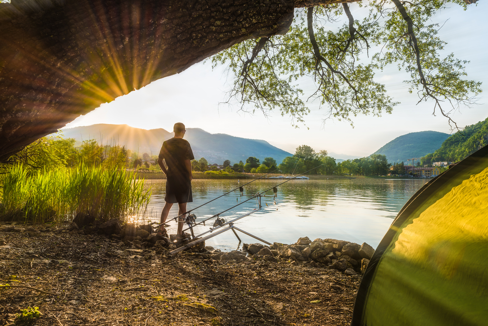 A man fishing for bass in summer.