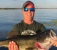 Male holding lunker Bass on lake