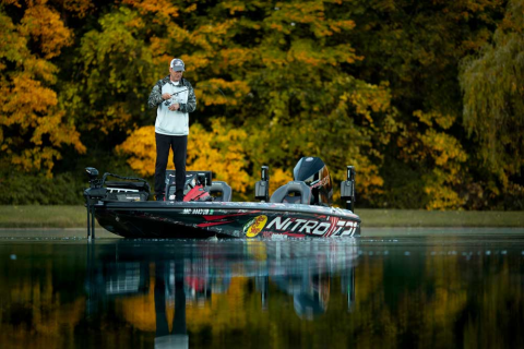 Angler fishing for bass on a rainy day, showing how the weather affects bass fishing conditions.