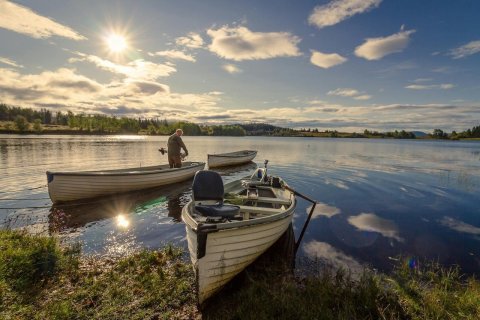 An angler standing in a boat and preparing for summer bass fishing.